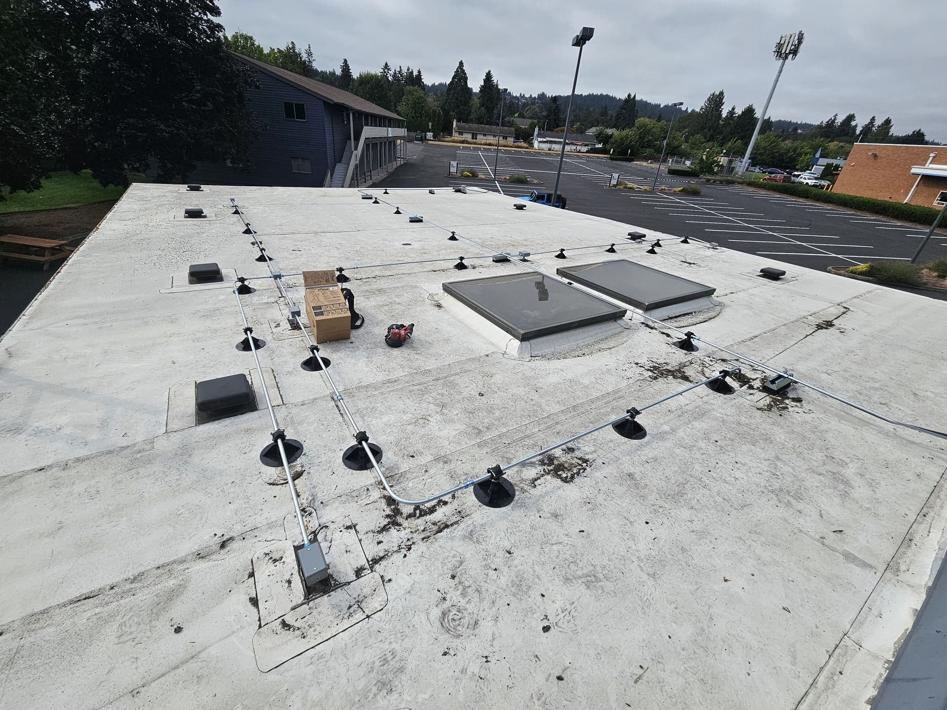 Conduit runs racked across a flat roof and dropped into a weatherproof enclosure