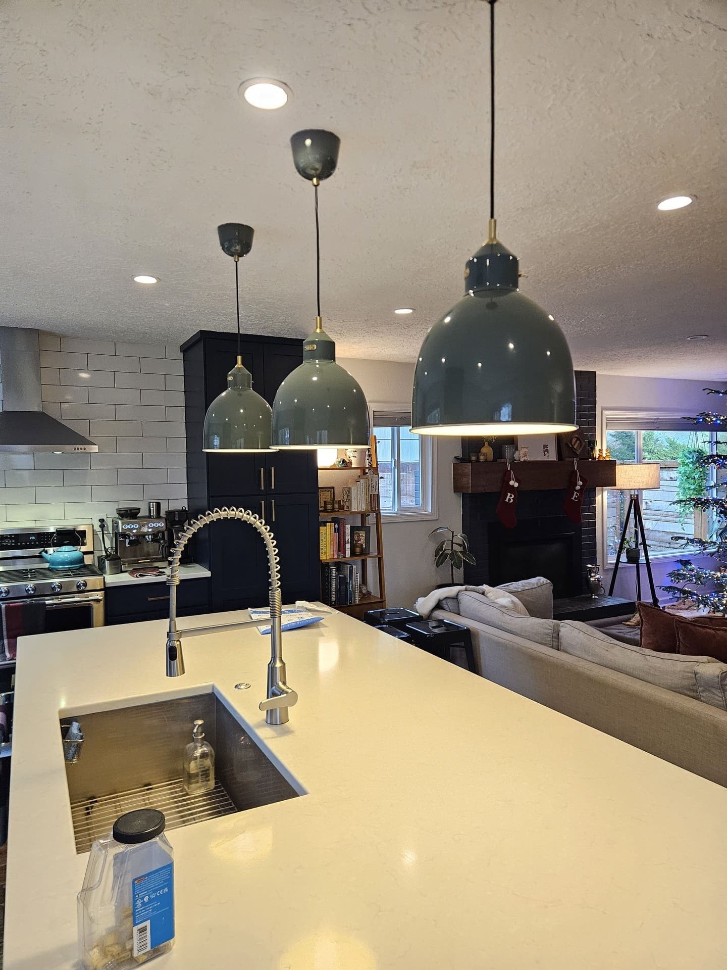 A lit orb chandelier hanging in a two storey entry hall above the front door and an arched window