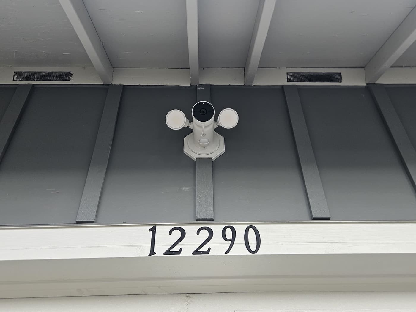 Security camera installed under a house eave and wired to its own box