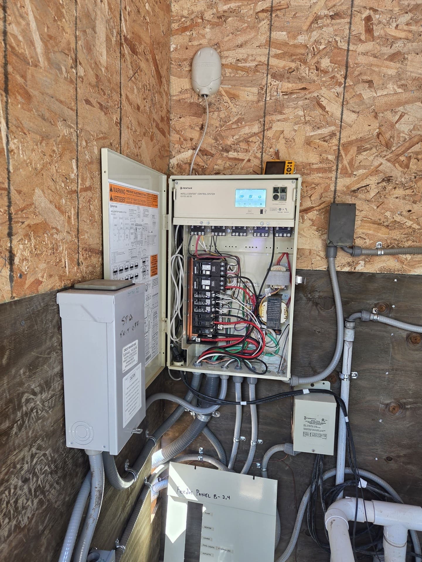 A pool and spa control panel wired out, with the breakers landed and every conduit run into the enclosure