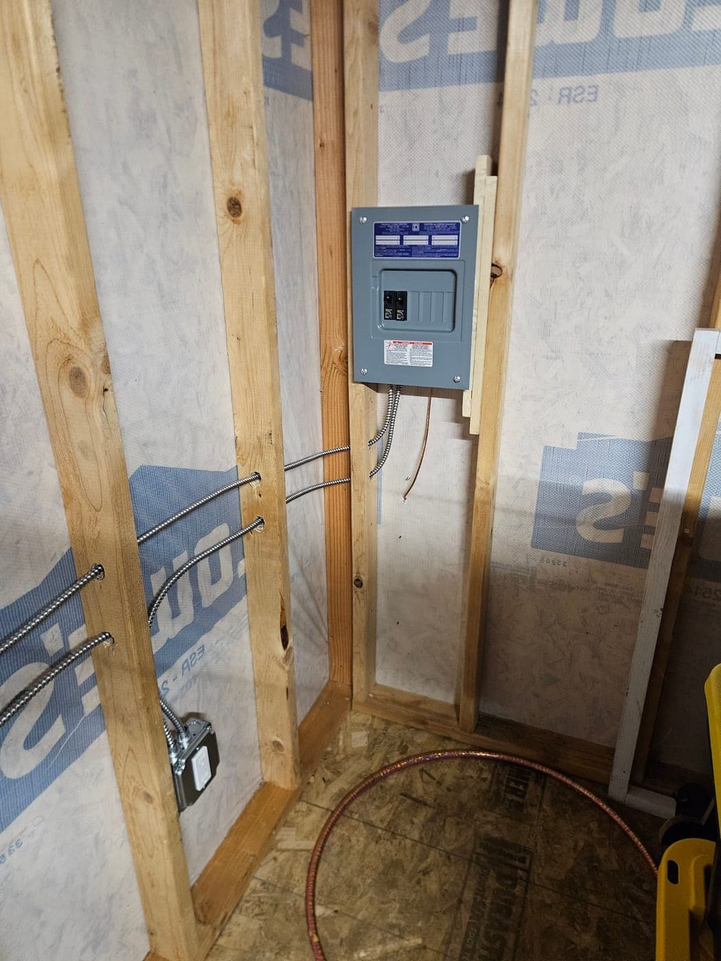 A new subpanel mounted between studs with its armoured branch circuits run out through the framing