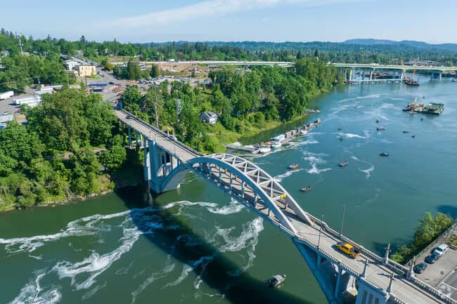 The Oregon City Bridge over the Willamette River between West Linn and Oregon City, with boats below the falls