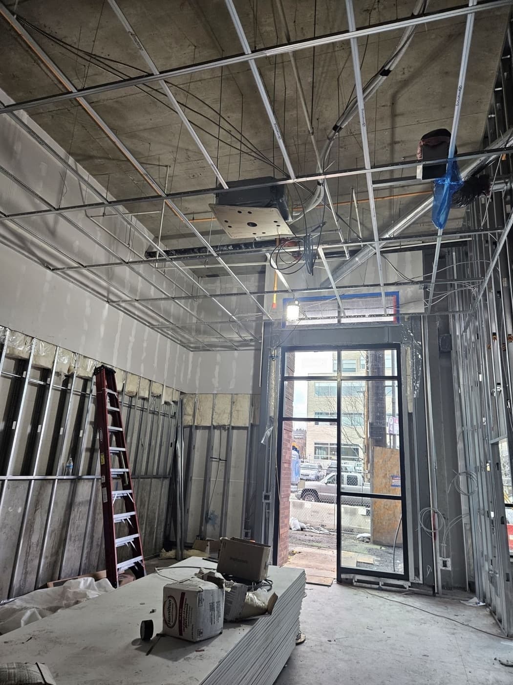 Commercial lighting and circuits run above a drop ceiling grid during a tenant fit out