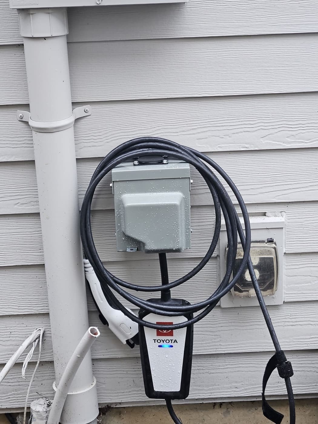 Outdoor EV charger and its disconnect mounted on house siding