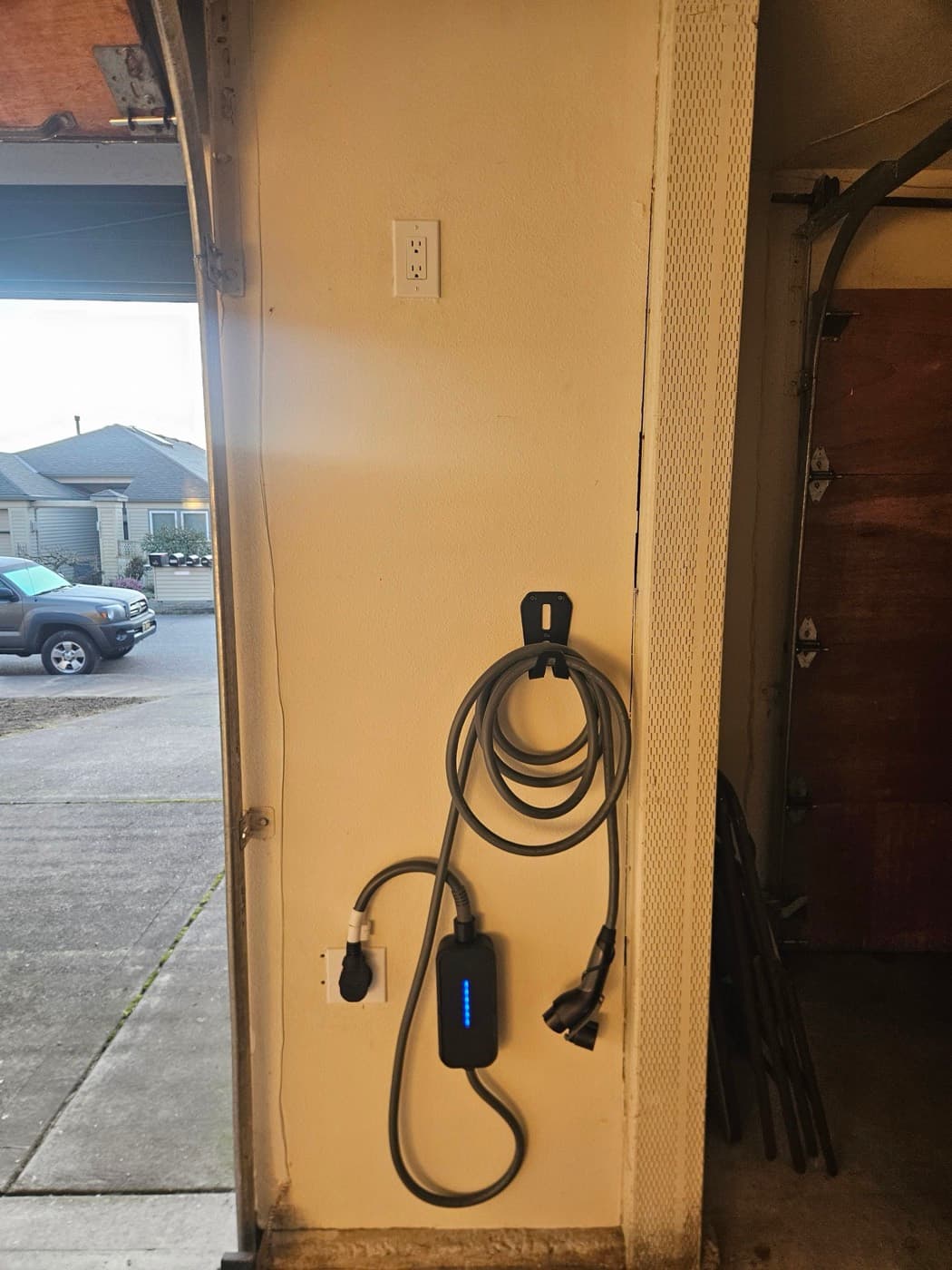 EV charger mounted inside a garage door opening within reach of the driveway