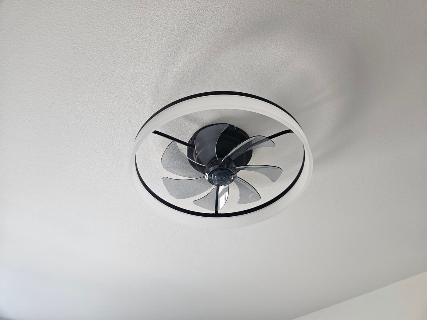 Ceiling fan with an integrated light fitted in place of an existing fixture