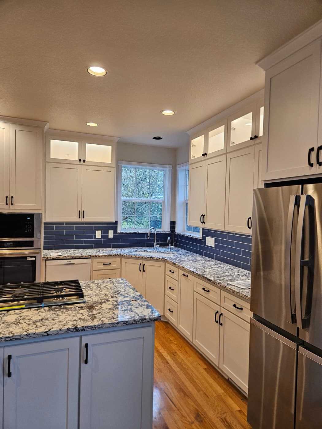 Kitchen lighting with recessed cans, under cabinet strips and lit glass fronted upper cabinets