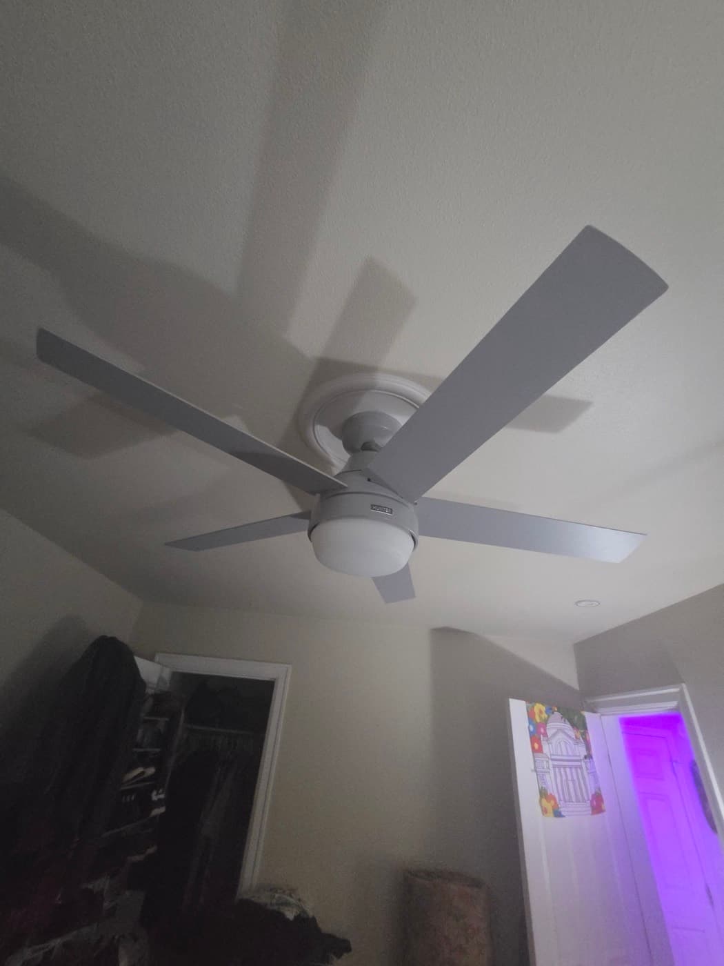 Ceiling fan hung from a vaulted ceiling with recessed cans set around it