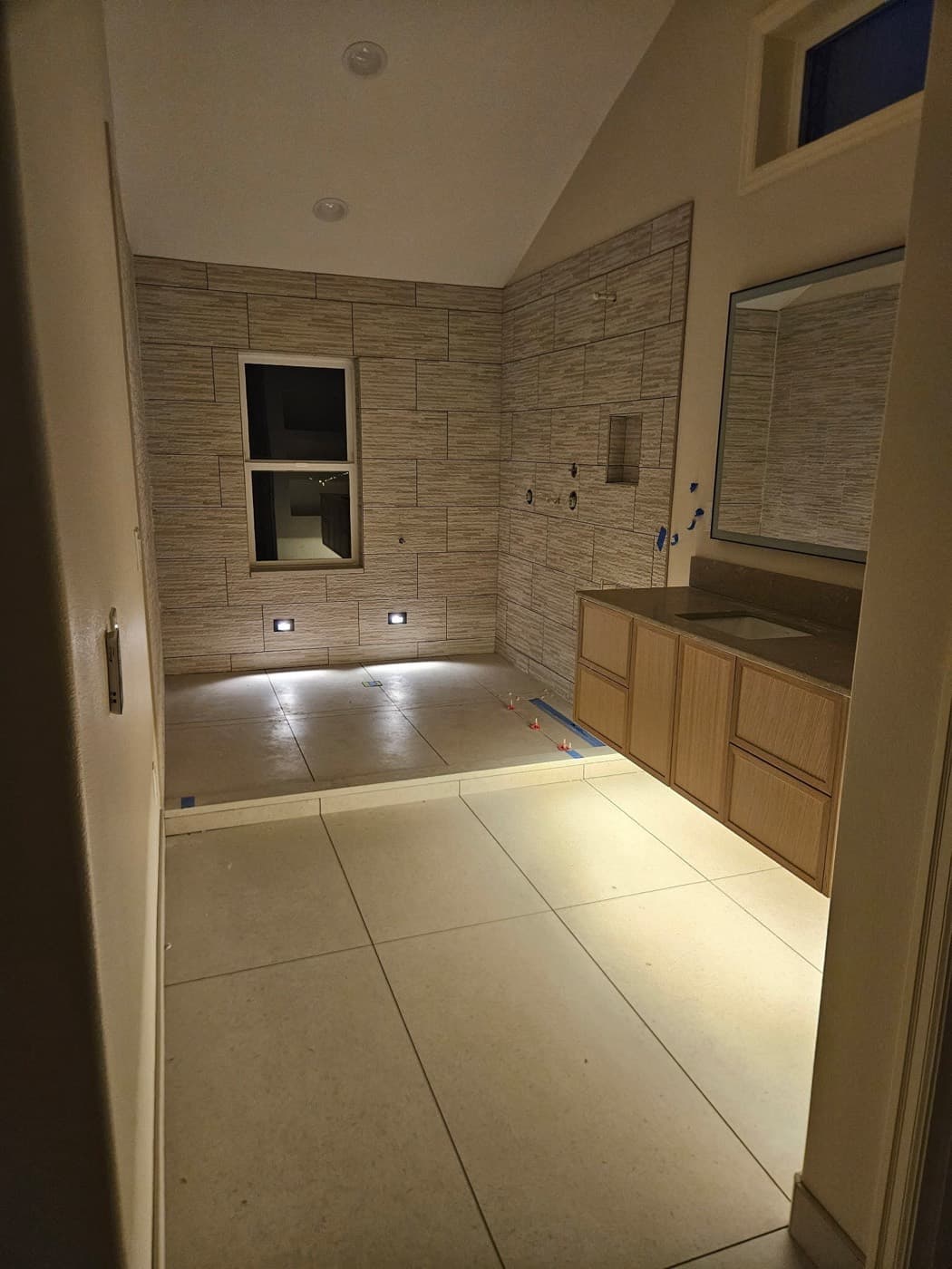 Bathroom with lighting worked into the shower niche and the toe kick
