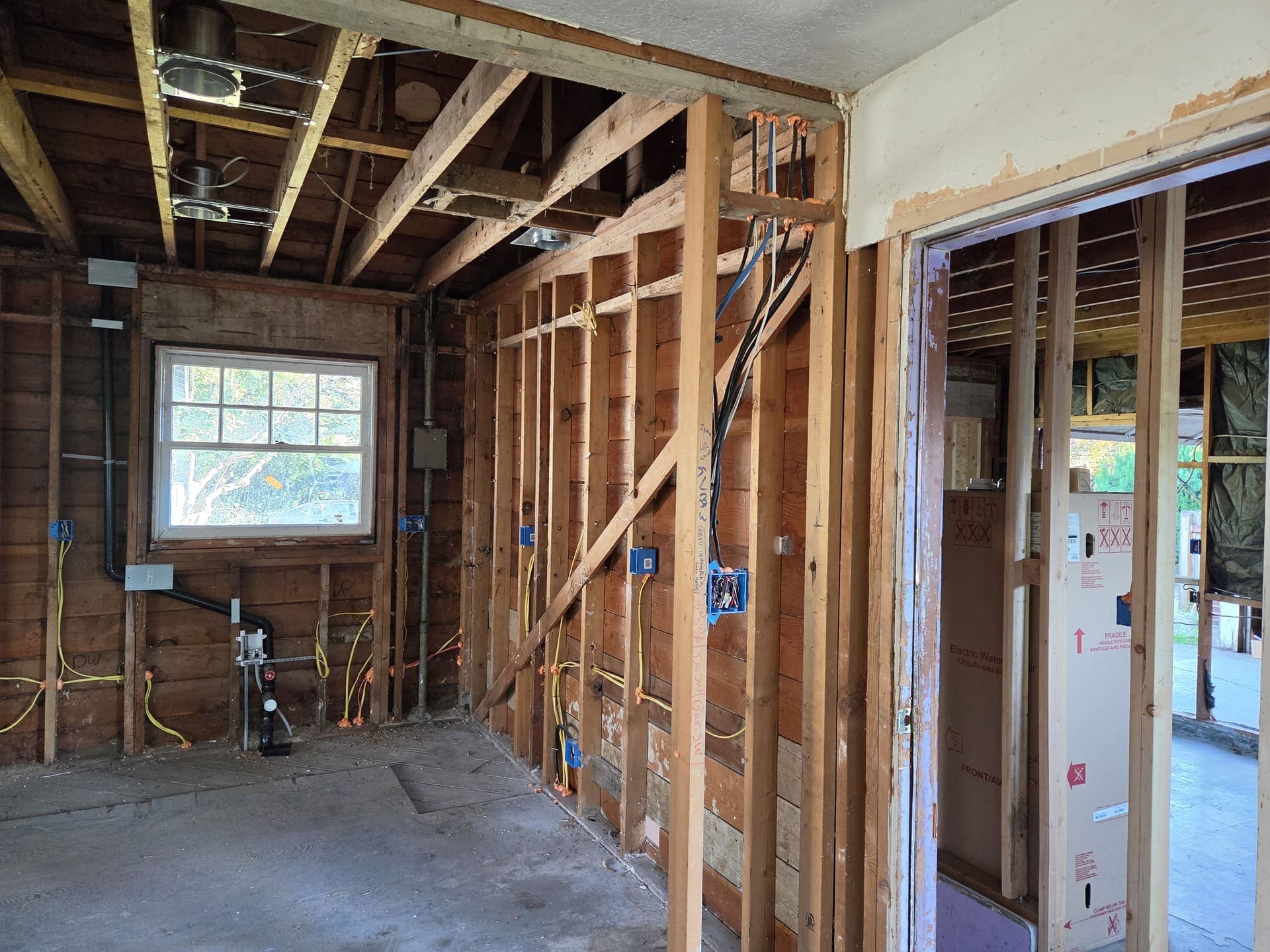 A room opened to the studs during a rewire, with new circuits run to boxes set for the finished walls