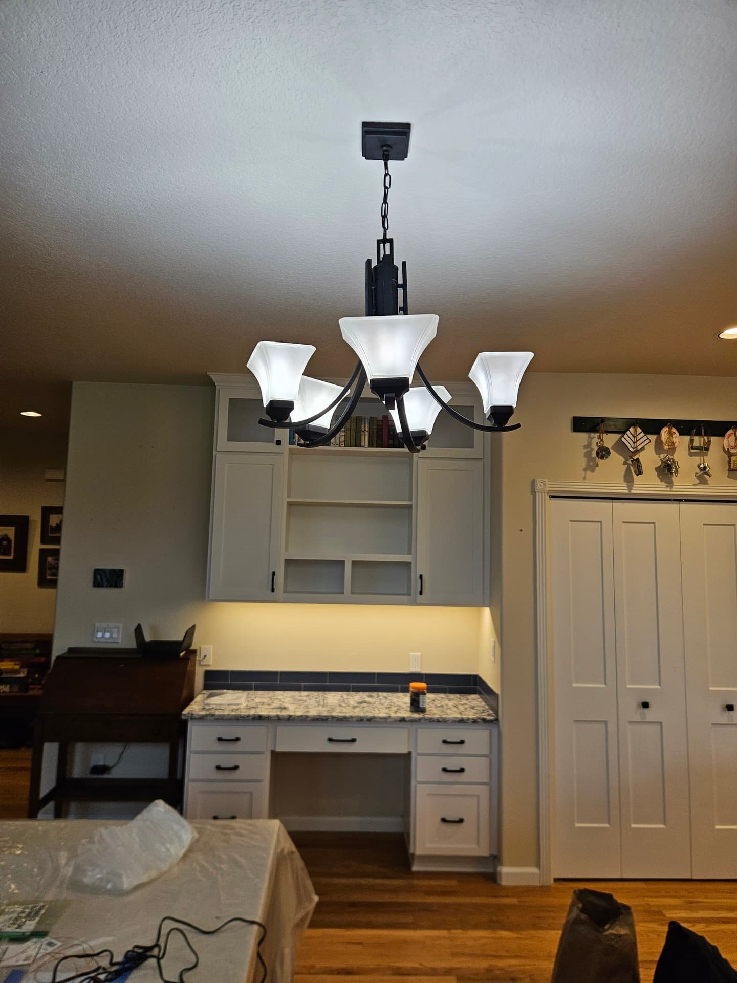 A five-arm lantern pendant hung on a chain over an entry, lit warm