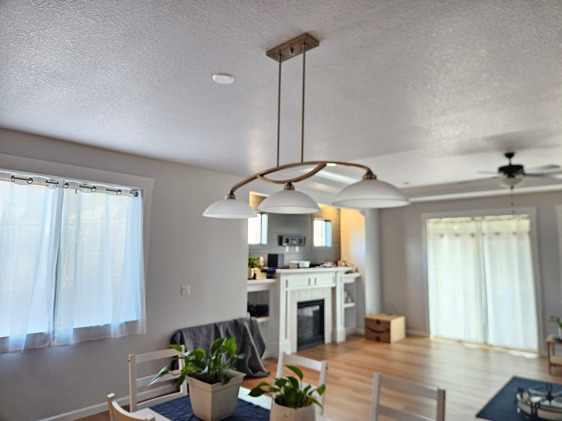 Three dome pendants hung in a row over a kitchen island on a warm evening